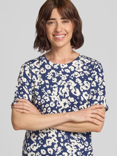 Frauenmodel trägt T-Shirt im Allover-Look mit Rundhalsausschnitt von Marc Cain aus Baumwoll-Elasthan-Mix, blau-creme, Nahaufnahme Oberkörper.