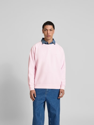 Männermodel trägt Relaxed Fit Sweatshirt aus Baumwolle von Closed in Hellrosa mit Raglanärmel, Rundhalsausschnitt, elastische Abschlüsse, Rückenlänge bei Größe M 71 cm, Ganzkörperansicht von vorne.
