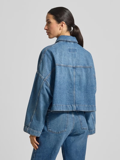 Frauenmodel trägt Relaxed Fit Jeansjacke Modell 'HOLBROOKS' von Drykorn aus reiner Baumwolle, mittleres Blau, Rückansicht, Ganzkörperansicht Rückansicht.