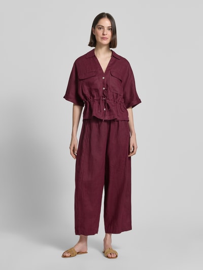 Frauenmodel trägt Relaxed Fit Leinenbluse mit Brusttaschen von Christian Berg Woman in Dunkelrot, strukturierte Oberfläche, Ganzkörperansicht von vorne.