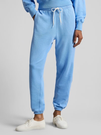 Frauenmodel trägt Relaxed Fit Sweatpants aus reiner Baumwolle von Polo Ralph Lauren, unifarben hellblau mit Logo, Nahaufnahme Unterkörper.