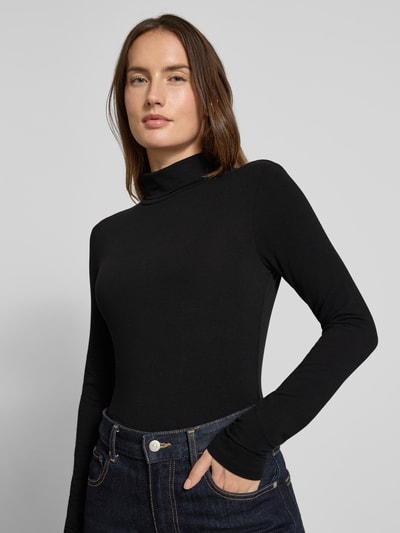 Frauenmodel trägt Slim Fit Turtleneck mit Viskose-Anteil von Tom Tailor Denim, Optik: Unifarben, Passform: Slim-Fit, Kragenform: Turtleneck, Ärmelform: Langarm, Material: Viskose-Mix, Ganzkörperansicht von vorne.