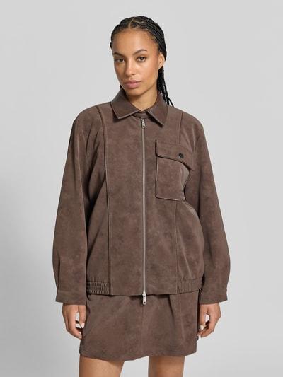 Frauenmodel trägt Oversized Blouson aus Viskose-Mix von BAUM & PFERDGARTEN in brauner Wildleder-Optik mit Zweiwege-Reißverschluss, Nahaufnahme Oberkörper.