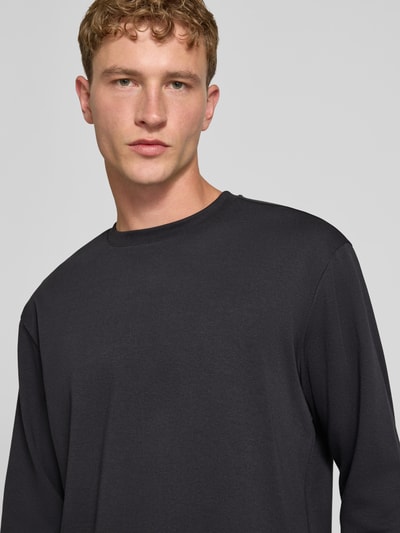 Männermodel trägt Relaxed Fit Langarmshirt aus Baumwoll-Mix Modell 'SCASPIAN' von ONLY, dunkelgrau, glatte Textur, Nahaufnahme Oberkörper. Herren T-Shirt von ONLY