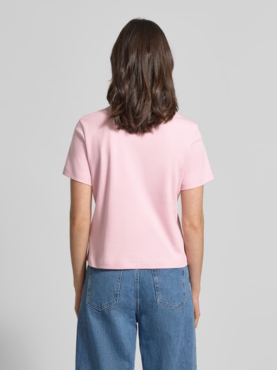 Frauenmodel trägt Slim Fit T-Shirt aus reiner Baumwolle von Tommy Hilfiger, Optik: Unifarben, Passform: Slim-Fit, Label-Print, Rundhals, Kurzarm, Materialverarbeitung: Jersey, Damen T-Shirt, Farbe Rosa, Ganzkörperansicht Rückansicht.