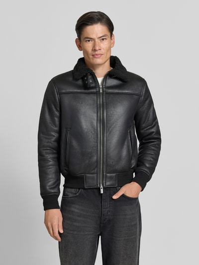 Männermodel trägt schwarze Regular Fit Jacke in Leder-Optik Modell 'Aviator' von MARKUP mit Kunstfellbesatz, Ganzkörperansicht von vorne.