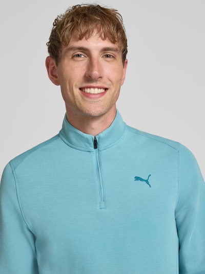 Männermodel trägt Sweatshirt mit Label-Detail Modell 'CLOUDSPUN' von PUMA PERFORMANCE in Hellblau, Nahaufnahme Oberkörper, elastischer Material-Mix