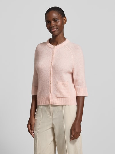 Frauenmodel trägt Cardigan mit Eingrifftasche Modell 'Dathena' von OPUS in zartem Rosa; Material-Mix mit Mohair-Anteil, Knopfleiste, gerader Schnitt, Rundhalsausschnitt, gerippte Abschlüsse; Ganzkörperansicht von vorne.