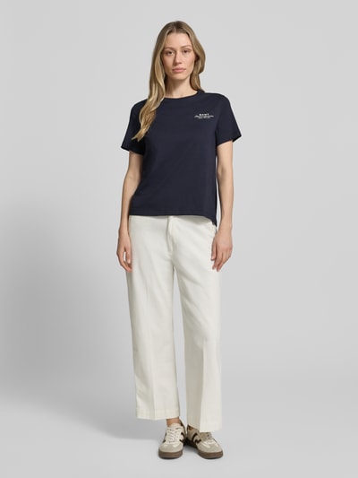 Frauenmodel trägt T-Shirt mit Label-Print und Rundhalsausschnitt von Gant in Dunkelblau, Reine Baumwolle, Regular-Fit, Rückenlänge bei Größe S 57 cm, Ganzkörperansicht von vorne