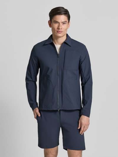 Männermodel trägt dunkelblaue Regular Fit Jacke mit Umlegekragen Modell 'Motion' von SCANDINAVIAN EDITION aus elastischem Material-Mix, Ganzkörperansicht von vorne.