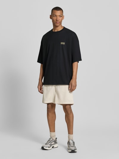 Männermodel trägt Herren T-Shirt mit Logo-Print Modell 'GIXY' von American Vintage aus Reine Baumwolle, Loose-Fit, Ganzkörperansicht von vorne.