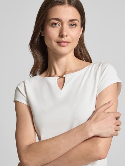 Kobiece modelka nosi T-Shirt mit Cut Out von Marc Cain, mieszanka modalu z dodatkiem streczu, prosty krój, drobne prążkowanie, okrągły dekolt, wycięcie, długość tyłu w rozmiarze 36: 56 cm, jasny kolor, struktura delikatna, zbliżenie na górną część ciała