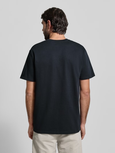 Männermodel trägt schwarzes Regular Fit T-Shirt mit Logo-Applikation von Under Armour aus Baumwoll-Mix, Ganzkörperansicht Rückansicht.