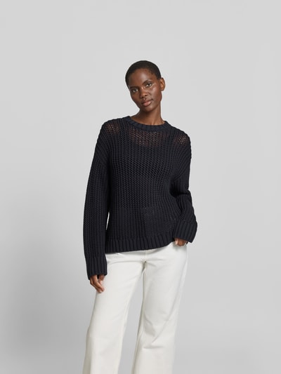 Frauenmodel trägt Pullover in Strick-Optik von Juvia aus Baumwoll-Mix, Relaxed-Fit, semitransparent, Rundhalsausschnitt, Ganzkörperansicht von vorne.