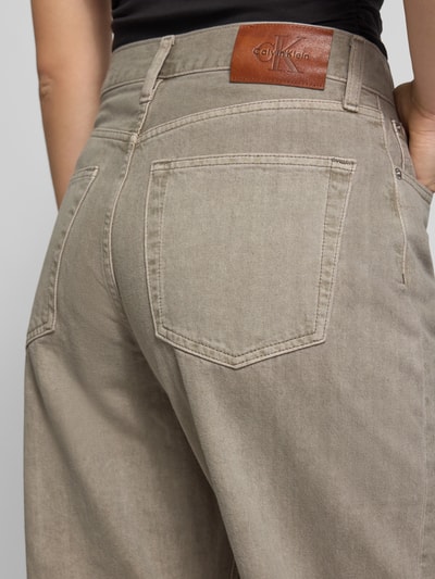 Frauenmodel trägt Barrel Jeans aus reiner Baumwolle von Calvin Klein Jeans in Beige mit sichtbarer Taschenstruktur, Nahaufnahme Rückansicht. Damen Barrel Jeans von Calvin Klein Jeans.