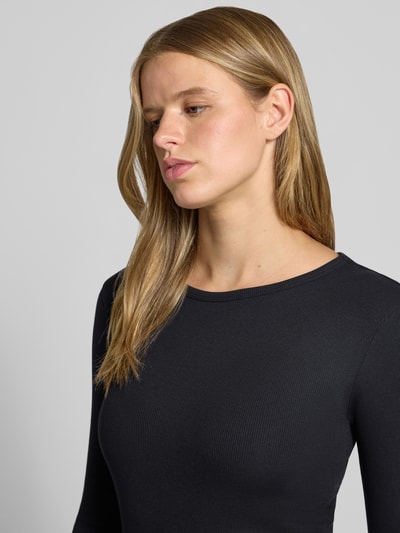 Frauenmodel trägt Longsleeve mit Rundhalsausschnitt von REVIEW, Baumwoll-Mix, eng anliegend, Ripp-Struktur, Nahaufnahme Oberkörper.