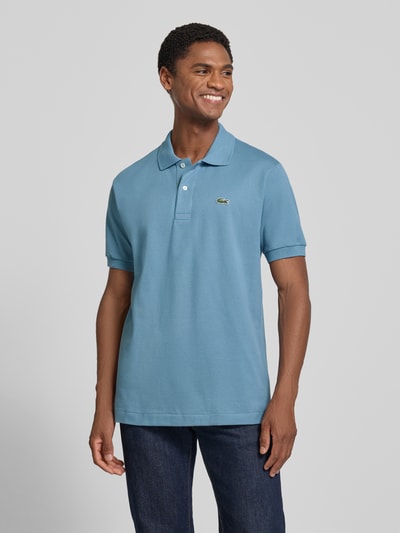 Męski model nosi koszulkę polo Regular Fit Poloshirt aus reiner Baumwolle Modell 'CORE' od Lacoste w niebieskim kolorze, Ganzkörperansicht von vorne. Koszulka polo Lacoste.