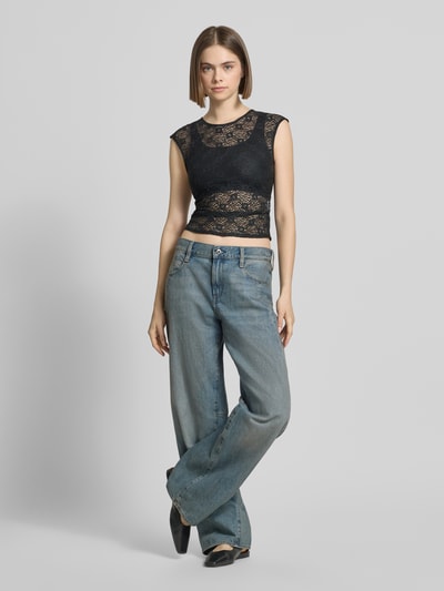 Frauenmodel trägt T-Shirt aus Spitze mit Raffung an der Seitennaht von REVIEW, Elastischer-Material-Mix, Körpernahe Passform, Rundhalsausschnitt, Rückenlänge bei Größe S 45 cm, schwarze Spitze mit transparenter Textur, Ganzkörperansicht von vorne.