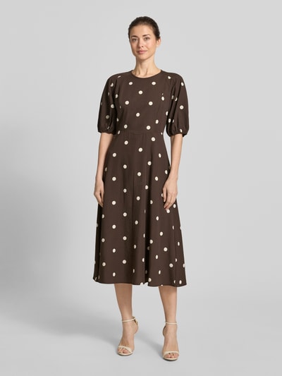 Frauenmodel trägt Midikleid aus Viskose-Mix im Allover-Look von Jake*s Casual, braun mit weißen Punkten, A-Linie, Puffärmel, Ganzkörperansicht von vorne.