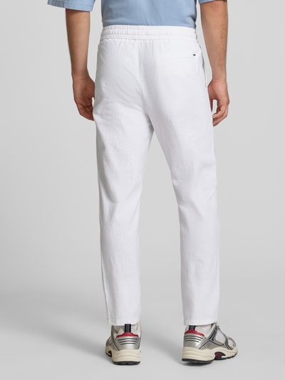 Männermodel trägt Tapered Leinenhose aus Baumwoll-Leinen-Mix Modell 'LINUS' von Only & Sons, weiße Melange-Optik, Ganzkörperansicht Rückansicht.