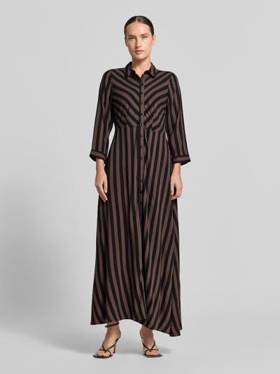 Vrouwenmodel draagt maxi-jurk uit zuiver viscose, model 'Savanna' van YAS met getailleerde pasvorm, all-over bloemenmotief, 3/4-mouw, zwart en bruin gestreept patroon, gladde textuur, geheel van voren gezien