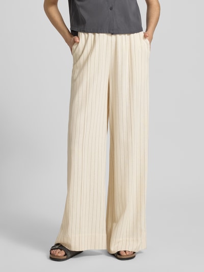 Frauenmodel trägt Loose Fit Pants mit Eingrifftaschen Modell 'tascha' von Gestuz, cremefarben, Viskose-Mix mit Leinen-Anteil, ausgestellter Schnitt, elastischer Bund, Bundweite 38 cm, Innenbeinlänge 81 cm, Ganzkörperansicht von vorne.