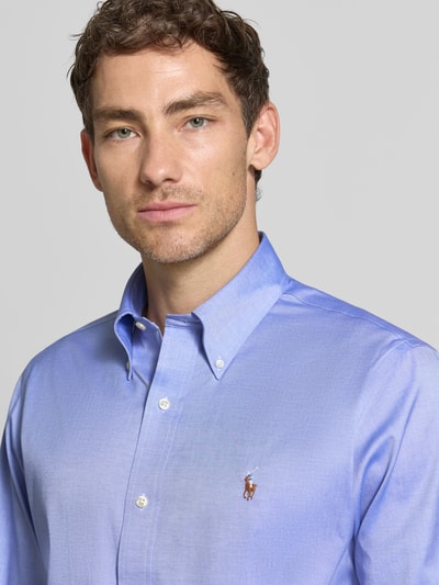 Männermodel trägt Regular Fit Businesshemd aus reiner Baumwolle von Polo Ralph Lauren in Hellblau mit glatter Textur, Nahaufnahme Oberkörper.