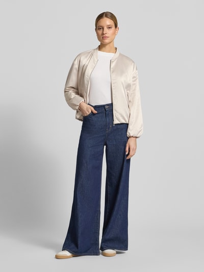 Kobiece modelka nosi Regular Fit Blouson mit College-Kragen von Tom Tailor, efekt: jednolity kolor, krój regular fit, kołnierz college, zamek błyskawiczny, długi rękaw, elastyczne zakończenia rękawów i dołu, wpuszczane kieszenie boczne, wykończenie materiału: satyna, jasny beżowy, gładka tekstura, widok całej sylwetki z przodu.