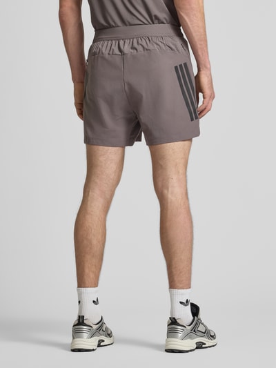 Männermodel trägt Regular Fit Sport-Shorts mit elastischem Bund von adidas Training, jednokolorowe, krój regular fit, nadruk z logo, wstawka z siateczki, elastyczny ściągacz, wpuszczane kieszenie, całkowity widok z tyłu