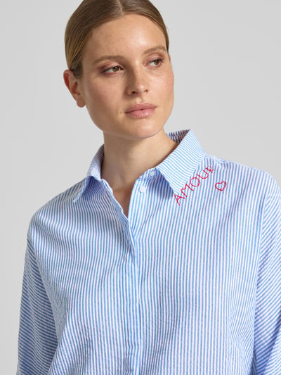 Frauenmodel trägt Relaxed Fit Bluse mit Stitchings und 3/4-Arm von Oui, feine blaue Streifen, Reine Baumwolle, Nahaufnahme Oberkörper. Rückenlänge 70 cm, Ärmellänge 53 cm bei Größe 36.