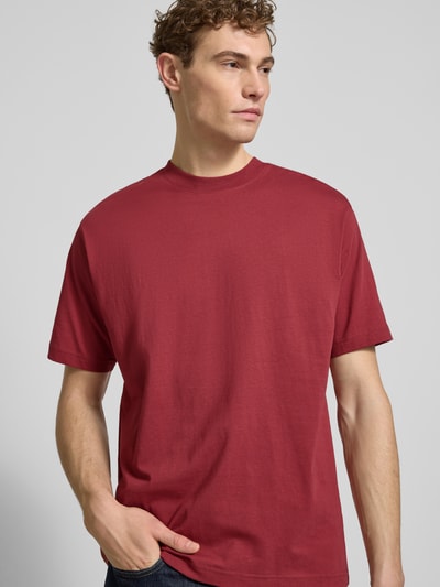 Männermodel trägt Regular Fit T-Shirt aus reiner Baumwolle von MCNEAL in Dunkelrot, Rundhals, kurzärmelig, Ganzkörperansicht von vorne.