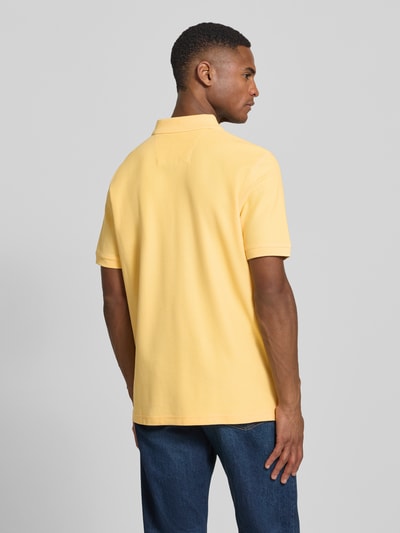 Männermodel trägt Regular Fit Poloshirt mit Logo-Stitching von Fynch-Hatton in Gelb aus Reine Baumwolle, Rückenlänge 70 cm, Ganzkörperansicht Rückansicht.