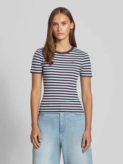 Kobiece modelka nosi prążkowany damski t-shirt Slim Fit T-Shirt aus Baumwoll-Mix model 'VAL' od ONLY w granatowo-białe paski, widok całej sylwetki z przodu.