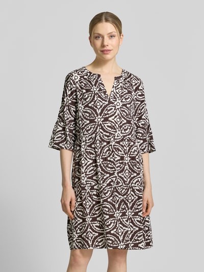 Frauenmodel trägt Regular Fit Minikleid aus reiner Viskose mit Kachel-Print von Christian Berg Woman Selection, taillierte Passform, Tunika-Ausschnitt, Halbarm, braune und weiße Farben, strukturierte Optik, Ganzkörperansicht von vorne.