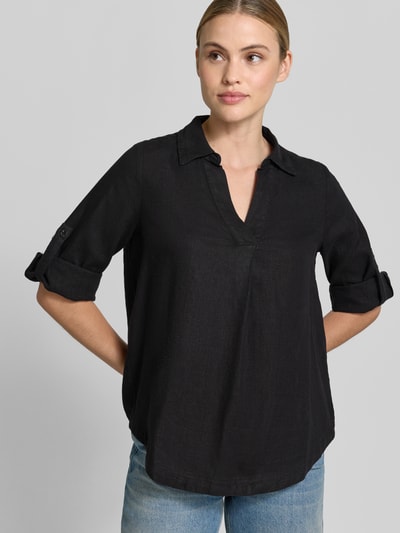 Vrouwenmodel draagt Relaxed Fit Hemdbluse aus Leinen-Viskose-Mix van s.Oliver RED LABEL, effen zwart, lange mouwen met turn-up, v-hals, hemdkraag, flammé-textuur, detail rugpas met Cacharel-plooitje, vooraanzicht bovenlichaam.