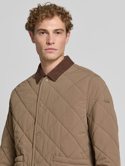 Männermodel trägt Regular Fit Jacke in Stepp-Optik Modell 'Rapid' von CINQUE in Beige mit Umlegekragen und Knopfleiste, Nahaufnahme Oberkörper.