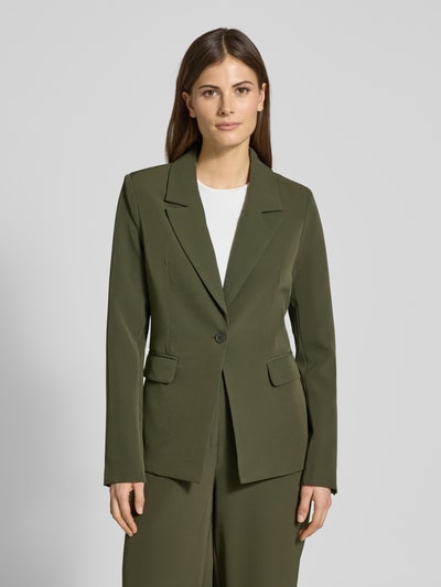 Frauenmodel trägt Slim Fit Blazer mit Pattentaschen Modell 'ISA' von Guido Maria Kretschmer, olivgrün, Material-Mix mit Stretch-Anteil, Reverskragen, Ganzkörperansicht von vorne.