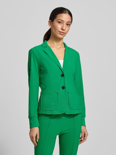 Modelka kobieca nosi Blazer mit Knopfverschluss od Marc Cain, zielony, materiał z domieszką stretchu, krój taliowany, kołnierz z klapami, kieszenie wpuszczane, długość tyłu w rozmiarze 36: 57 cm, szerokość w rozmiarze 36: 48 cm, długość rękawa w rozmiarze 36: 61 cm, widok całej sylwetki z przodu.
