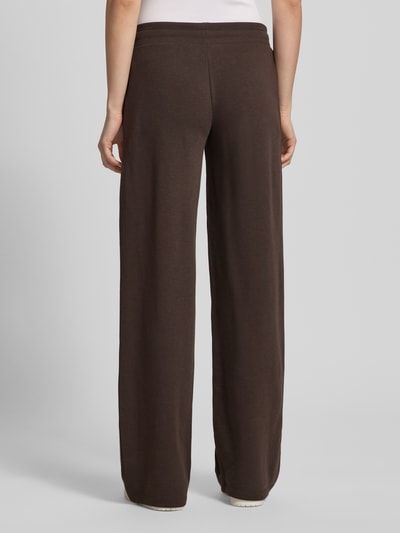 Männermodel trägt Straight Fit Sweatpants mit Tunnelzug von REVIEW, mieszanka bawełny, krój straight fit, elastyczny pas, tunel, długość wewnętrzna nogawki 85 cm w rozmiarze S, brązowy kolor, widok całej sylwetki od tyłu.