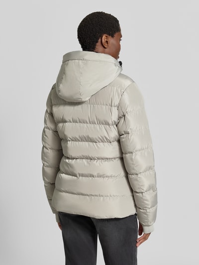 Vrouwenmodel draagt Regular fit gewatteerd jack in Model 'Synria' van Cars Jeans, Stiksels, capuchon met opstaande kraag, Steekzakken, ritssluiting, Ruglengte maat S: 65 cm, Schouderbreedte: 42 cm, Borstwijdte: 50 cm, Mouwlengte: 70 cm, Ganzijde achterkant.