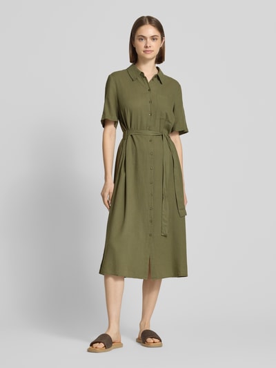 Kobiece model nosi Figurę podkreślającą sukienkę casualową z mieszanki wiskozy i lnu Pieces, model 'PIA', efekt: jednolity kolor, długość midi, dekolt w serek, listwa guzikowa, krótki rękaw, brustasza, wykończenie materiału: cieniowana przędza, widok całej sylwetki z przodu.