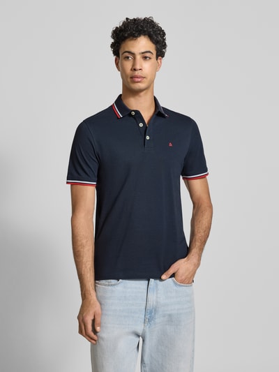 Männermodel trägt Slim Fit Poloshirt mit Viskose-Anteil Modell 'Paulos' von JACK & JONES, Baumwoll-Mix, Dunkelblau, Kurzärmelig, Logo-Stitching, Ganzkörperansicht von vorne. Rückenlänge bei Größe M: 72 cm.