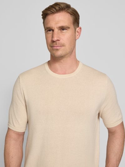 Männermodel trägt Strickshirt mit Kaschmir-Anteil und Knopfleiste von FTC-Cashmere, Beige, Baumwoll-Mix, Slim-Fit, Nahaufnahme Oberkörper.