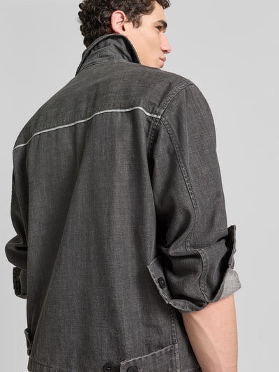 Männermodel trägt Regular Fit Jeansjacke aus Baumwoll-Mix von ANNARR in Grau, Kontrastnähte, Denim, Nahaufnahme Rückenansicht. Rückenlänge 70 cm, Schulterbreite 54 cm, Ärmellänge 65 cm, Zweiwege-Reißverschluss, Umlegekragen, Größe M.