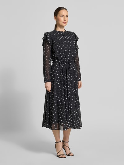 Vrouwenmodel draagt 'Midikleid im Allover-Look mit Bindegürtel' van JOOP!, zwart met witte stippen, A-lijn, ronde hals, volants, strikceintuur, ruglengte maat 36: 120 cm, borstwijdte maat 36: 47 cm, mouwlengte maat 36: 63 cm, geheellichaamsaanzicht van voren.