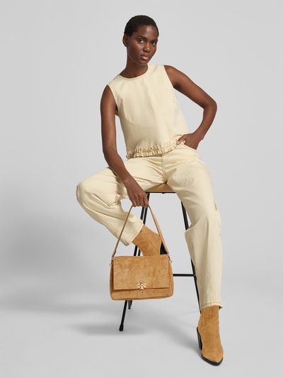 Frauenmodel trägt Shoulder Bag in Suede-Optik von Tory Burch in Beige mit Abnehmbarem Schulterriemen, Magnetverschluss, Innenfach mit Reißverschluss, Maße: 27 cm Breite, 18 cm Länge, 10 cm Tiefe, Ganzkörperansicht von vorne.