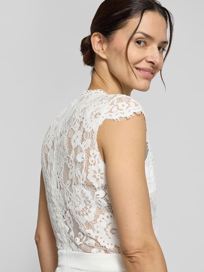 Frauenmodel trägt Brautkleid in Midilänge Modell 'Lilia' von GUIDO MARIA KRETSCHMER WOMAN mit Spitzenoberteil, Nahaufnahme Oberkörper Rückansicht.