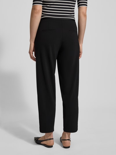 Frauenmodel trägt Stoffhose in verkürzter Passform Modell 'ELENA' von Cambio, Material-Mix, lockerer Schnitt, Gesäßtaschen, Ganzkörperansicht Rückansicht.