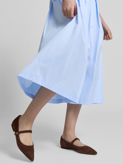 Frauenmodel trägt hellblauen Midirock mit Eingrifftaschen Modell 'KYLIE' von 0039 Italy, Baumwoll-Mix, A-Linie, Nahaufnahme Unterkörper.