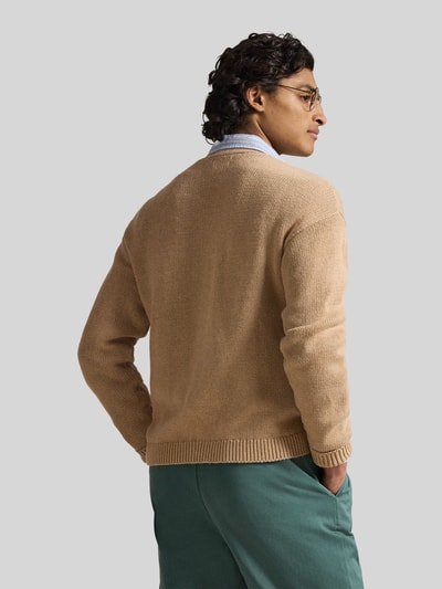 Męski model nosi Regular Fit Strickjacke aus reiner Baumwolle od Polo Ralph Lauren, jednolity beżowy, krój regular fit, bawełniany, całkowity widok od tyłu.